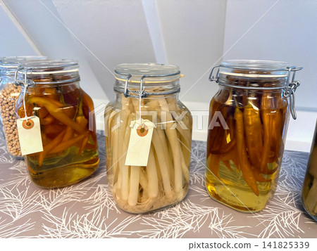 Pickled vegetables in glass jars on shelf Pickled vegetables in glass jars on shelf 141825339