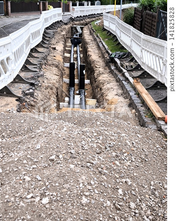 Laying new underground pipes in a trench along a city street. Laying new underground pipes in a trench along a city street. 141825828