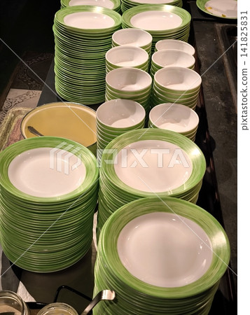 Stacks of clean green and white plates and bowls on the buffet. Stacks of clean green and white plates and bowls on the buffet. 141825831