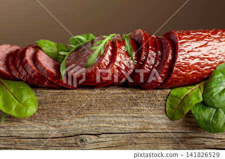 Sliced salami on a old wooden board. Sliced salami on a old wooden board. 141826529