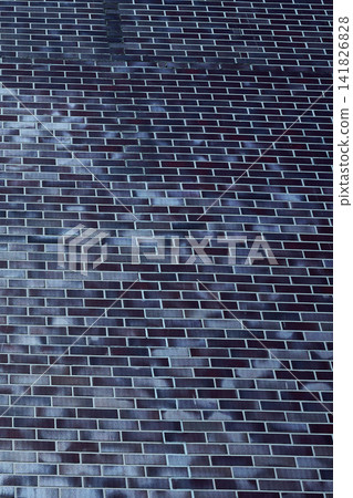 The view shows a roof made of dark bricks taken from above in a residential neighborhood under clear blue sky at midday The view shows a roof made of dark bricks taken from above in a residential neighborhood under clear blue sky at midday 141826828