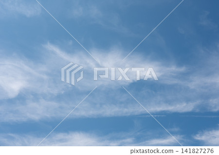 Light white cirrus clouds create a soft airy pattern against a clear blue summer sky. Light white cirrus clouds create a soft airy pattern against a clear blue summer sky. 141827276