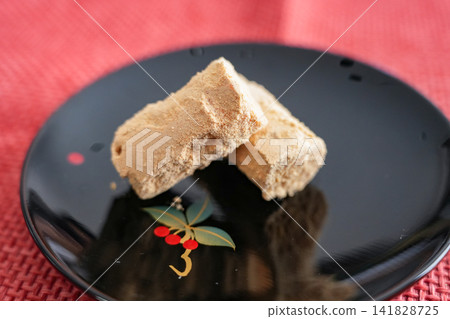 五花肉盛在黑色盤子裡,上面撒滿了黃豆粉。 五花肉盛在黑色盤子裡,上面撒滿了黃豆粉。 141828725