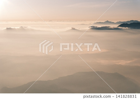A morning scene where the light of the rising sun spreads across the misty mountain range. A morning scene where the light of the rising sun spreads across the misty mountain range. 141828831