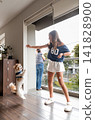 Little fluffy dog jumping up to catch a treat from a young girl 141828900