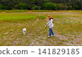 A white Shiba Inu enjoying a walk on the beach. 141829185