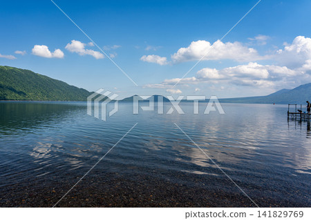 支笏湖湖面清澈湛藍,映著藍天白雲。 支笏湖湖面清澈湛藍,映著藍天白雲。 141829769
