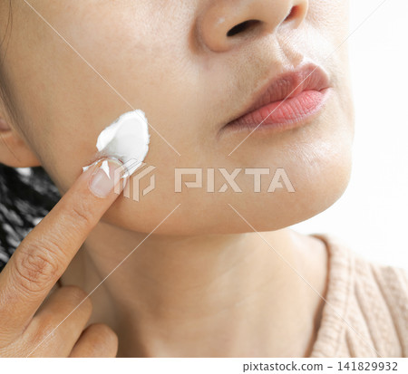 Woman apply lotion cream moisturizer on face, lifestyle clean spa treatment natural aroma therapy wellness skin care, perfec girl skin tan authentic, beauty aesthetic cosmetic product concept. Woman apply lotion cream moisturizer on face, lifestyle clean spa treatment natural aroma therapy wellness skin care, perfec girl skin tan authentic, beauty aesthetic cosmetic product concept. 141829932