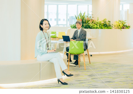 A businesswoman in her 50s working in a co-working space. A businesswoman in her 50s working in a co-working space. 141830125