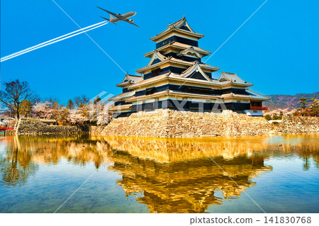 一張合成照片,展現了雄偉的松本城和天空中的飛機尾跡。 一張合成照片,展現了雄偉的松本城和天空中的飛機尾跡。 141830768