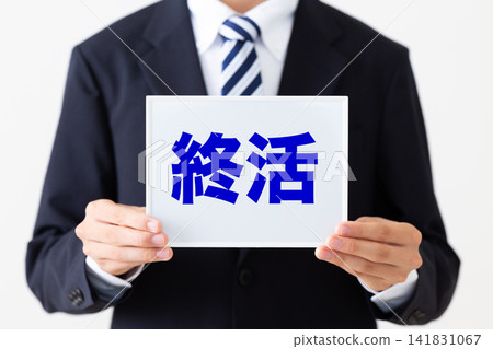 一位身穿西裝的年輕商人,手持一塊白板,上面寫著關於臨終關懷計畫的內容。 一位身穿西裝的年輕商人,手持一塊白板,上面寫著關於臨終關懷計畫的內容。 141831067