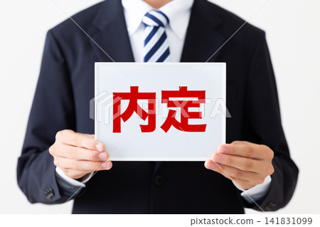 A young businessman in a business suit holding a whiteboard with job offers. A young businessman in a business suit holding a whiteboard with job offers. 141831099