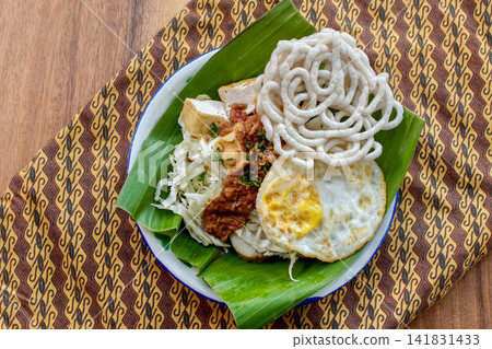 Traditional Indonesian Tahu Campur with Fried Egg and Crackers Traditional Indonesian Tahu Campur with Fried Egg and Crackers 141831433