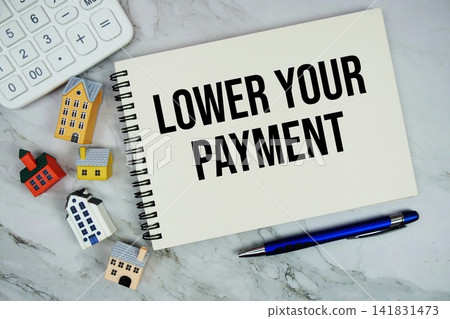 Lower Your Payment text written on notepad with house model and calculator on marble background Lower Your Payment text written on notepad with house model and calculator on marble background 141831473