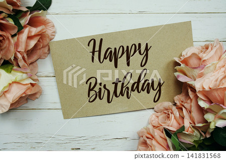 Happy Birthday text on paper card with rose flowers bouquet on wooden background Happy Birthday text on paper card with rose flowers bouquet on wooden background 141831568