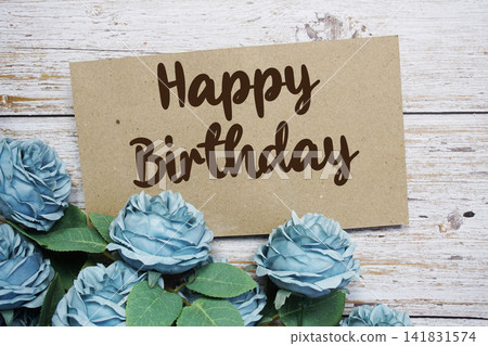 Happy Birthday text on paper card with rose flowers bouquet on wooden background Happy Birthday text on paper card with rose flowers bouquet on wooden background 141831574
