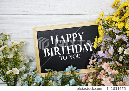 "Happy Birthday To You" Message on Chalkboard Surrounded by Colorful Flowers 141831653