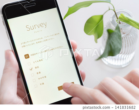 一張女性用智慧型手機填寫客戶問卷時雙手特寫照片(智慧型手機螢幕為原創設計)。 一張女性用智慧型手機填寫客戶問卷時雙手特寫照片(智慧型手機螢幕為原創設計)。 141831682