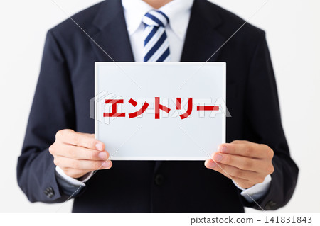 身穿西裝的年輕商人,手持一塊白板。 身穿西裝的年輕商人,手持一塊白板。 141831843