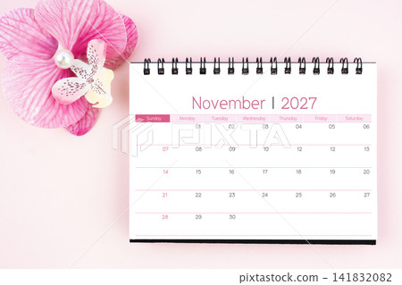 Desk calendar for November 2027 with pink orchid. Flat lay. Desk calendar for November 2027 with pink orchid. Flat lay. 141832082