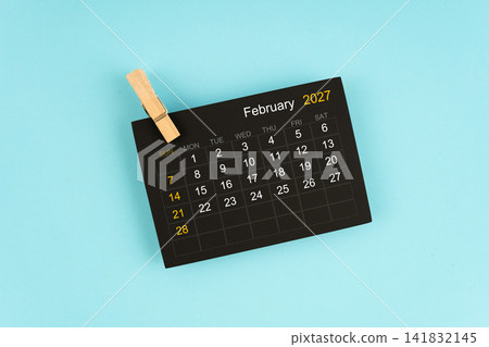 Black calendar sheet for February 2027 with wooden clips. Black calendar sheet for February 2027 with wooden clips. 141832145
