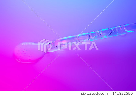 Cosmetic serum dropping from pipette onto vibrant background Cosmetic serum dropping from pipette onto vibrant background 141832590