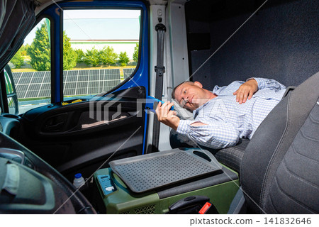 Van driver lying on front seats and checking navigation on his phone Van driver lying on front seats and checking navigation on his phone 141832646