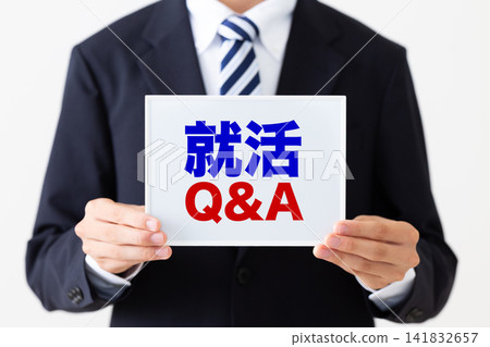 身穿西裝的年輕男性商務人士,手持一塊白板,上面有求職問答部分。 身穿西裝的年輕男性商務人士,手持一塊白板,上面有求職問答部分。 141832657