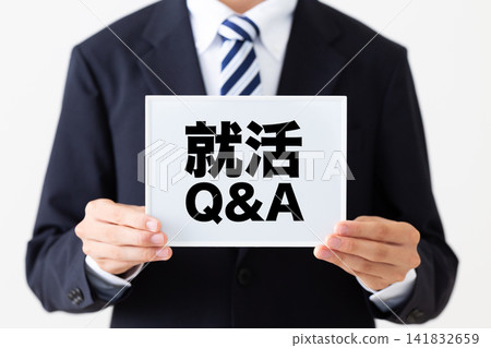 身穿西裝的年輕男性商務人士，手持一塊白板，上面有求職問答部分。 141832659