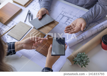 Closeup of Creative Architecture, Interior, Engineering Team Discussing Blueprint Layout and Renovation Materials. Closeup of Creative Architecture, Interior, Engineering Team Discussing Blueprint Layout and Renovation Materials. 141833793
