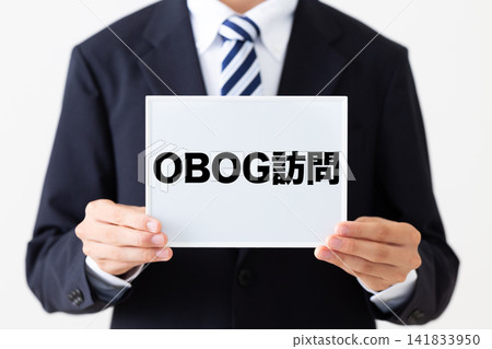 一位身穿西裝的年輕商人，手持白板，準備接待校友來訪。 141833950