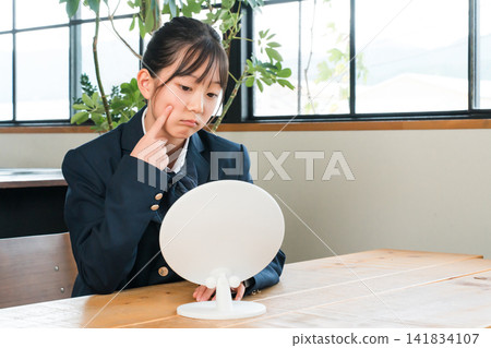 A girl in a uniform looking depressed in the mirror in the living room of her home (acne, rough skin, skin trouble) A girl in a uniform looking depressed in the mirror in the living room of her home (acne, rough skin, skin trouble) 141834107