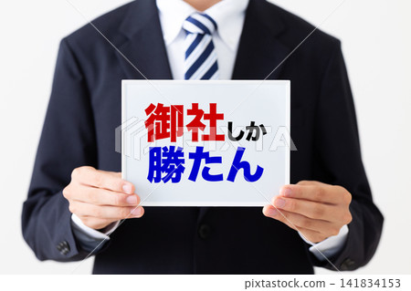 A young businessman in a business suit holding a whiteboard that reads "Only your company can win." A young businessman in a business suit holding a whiteboard that reads "Only your company can win." 141834153