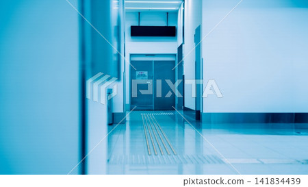 A corridor lined with tactile paving blocks and double doors illuminated by blue light. A corridor lined with tactile paving blocks and double doors illuminated by blue light. 141834439