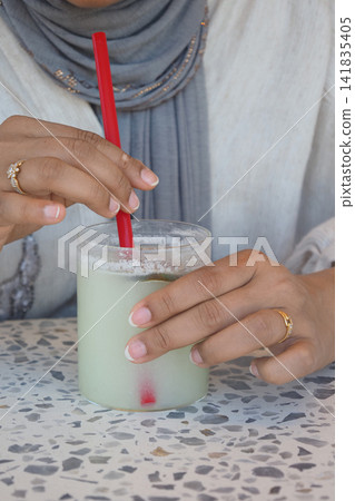 Drinking a cold beverage at a cafe Drinking a cold beverage at a cafe 141835405