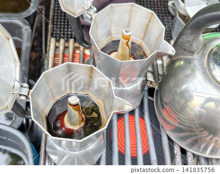Moka pots with brewing coffee on electric stove of retro cafe Moka pots with brewing coffee on electric stove of retro cafe 141835756