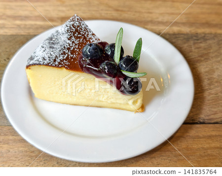 Cheesecake with ripe blueberries and mint on wood table 141835764