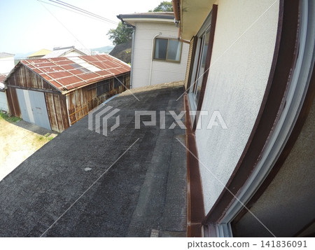 A house with a deteriorated slate roof. 141836091