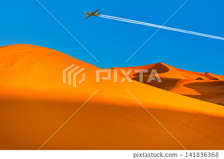 A composite image of an airplane flying over the scorching Sahara Desert. A composite image of an airplane flying over the scorching Sahara Desert. 141836368