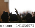 A holy worshipper raising both hands before the presence of the Holy Spirit to worship, praise, and pray to God, background of gatherings and retreats 141836573