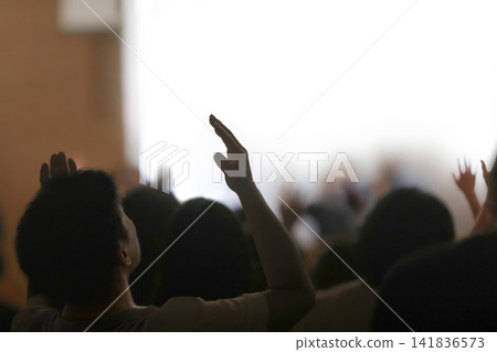 A holy worshipper raising both hands before the presence of the Holy Spirit to worship, praise, and pray to God, background of gatherings and retreats A holy worshipper raising both hands before the presence of the Holy Spirit to worship, praise, and pray to God, background of gatherings and retreats 141836573