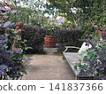 一個有鮮花、綠植和長椅的花園。 141837366