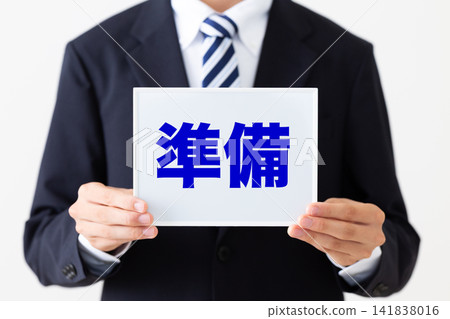 A young businessman in a business suit holding a whiteboard for preparations. A young businessman in a business suit holding a whiteboard for preparations. 141838016
