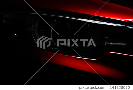 Closeup headlight of shiny red luxury SUV compact car. Elegant electric car technology and business concept. Hybrid auto and automotive concept. Car parked in showroom or motor show. Car dealership. Closeup headlight of shiny red luxury SUV compact car. Elegant electric car technology and business concept. Hybrid auto and automotive concept. Car parked in showroom or motor show. Car dealership. 141838050