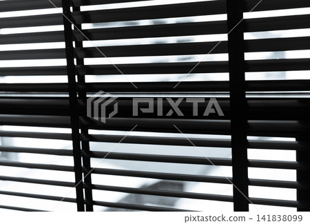 Window blinds with soft daylight filtering through horizontal slats. Abstract geometric pattern for privacy, interior design, modern architecture and minimal background use. Venetian plastic blinds. Window blinds with soft daylight filtering through horizontal slats. Abstract geometric pattern for privacy, interior design, modern architecture and minimal background use. Venetian plastic blinds. 141838099