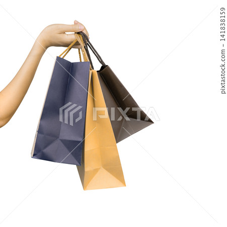 Woman carrying blue and brown paper shopping bags isolated on white background, representing consumer spending, retail purchasing, customer lifestyle, seasonal sales and Black Friday shopping concept. Woman carrying blue and brown paper shopping bags isolated on white background, representing consumer spending, retail purchasing, customer lifestyle, seasonal sales and Black Friday shopping concept. 141838159