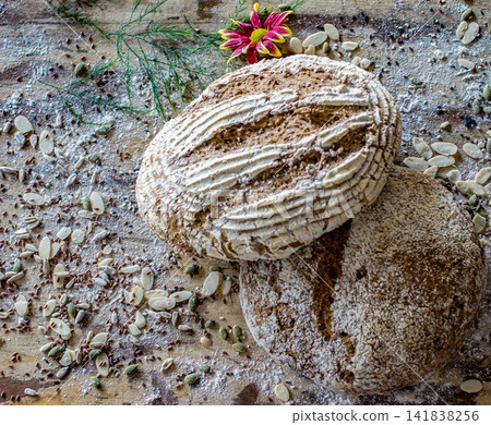 Rustic artisan bread loaves photographed from above on wooden table. Homemade bakery food concept. Rustic artisan bread loaves photographed from above on wooden table. Homemade bakery food concept. 141838256