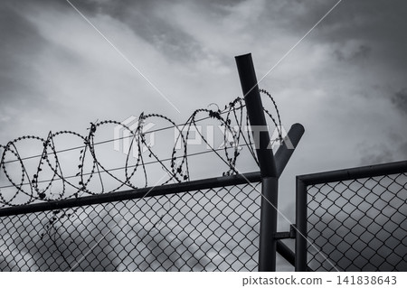 Prison security fence. Barbed wire security fence. Razor wire jail fence. Barrier border. Boundary security wall. Prison for arrest criminals or terrorists. Private area. Military zone concept. 141838643