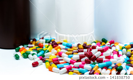 Pile of colorful antibiotic capsule pills on blur plastic drug bottle. Antibiotic drug resistance. Antibiotic drug overuse. Pharmaceutical industry. Polypharmacy. Antimicrobial drugs. Bright pills. Pile of colorful antibiotic capsule pills on blur plastic drug bottle. Antibiotic drug resistance. Antibiotic drug overuse. Pharmaceutical industry. Polypharmacy. Antimicrobial drugs. Bright pills. 141838750