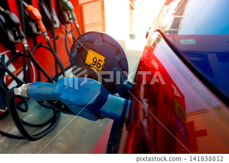 Car fueling at gas station. Refuel fill up with petrol gasoline. Petrol pump filling fuel nozzle in fuel tank of car at gas station. Petrol industry and service. Petrol price and oil crisis concept. Car fueling at gas station. Refuel fill up with petrol gasoline. Petrol pump filling fuel nozzle in fuel tank of car at gas station. Petrol industry and service. Petrol price and oil crisis concept. 141838812